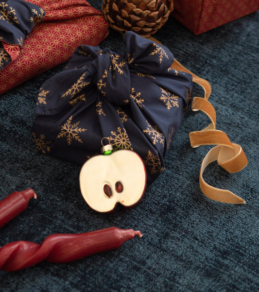 Stylish christmas gift wrapped in fabric on rustic table with scissors,  paper star, candle.Furoshiki Stock Photo by Sonyachny